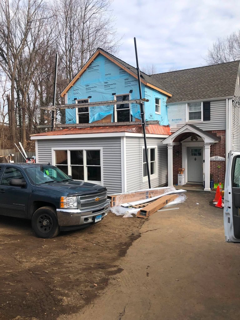Two-story residential addition with copper roof in progress