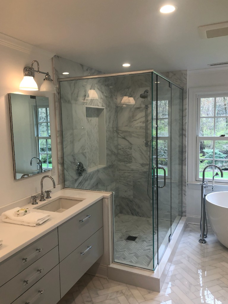 Luxury bathroom remodel with marble tile shower, freestanding tub, and vanity